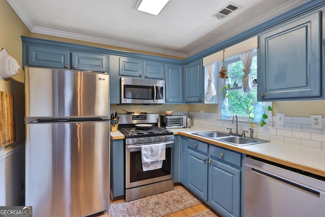 2675 Dacula Ridge Dr, Dacula, GA 30019 - kitchen with stainless steel appliances, blue cabinets, light countertops, and crown molding