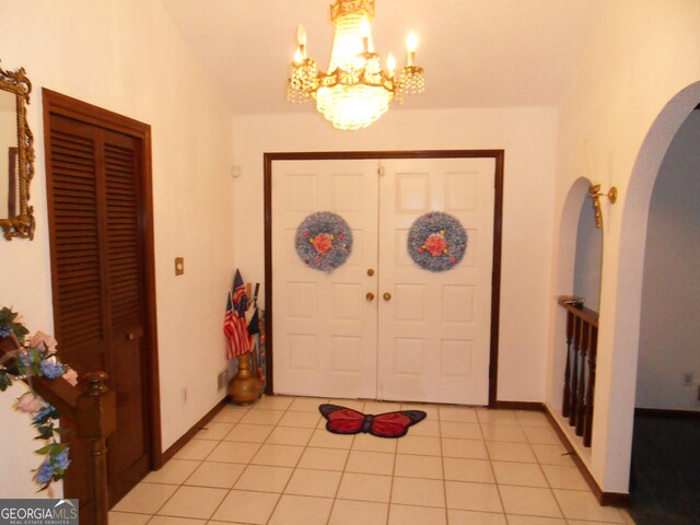 4213 Janice Dr, Atlanta, GA 30337 - foyer entrance with arched walkways, light tile patterned floors, a notable chandelier, and baseboards