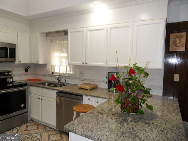 4213 Janice Dr, Atlanta, GA 30337 - kitchen featuring appliances with stainless steel finishes, a sink, backsplash, and white cabinets