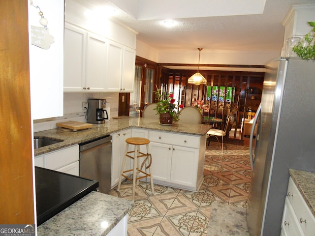 4213 Janice Dr, Atlanta, GA 30337 - kitchen with white cabinets, appliances with stainless steel finishes, and a peninsula