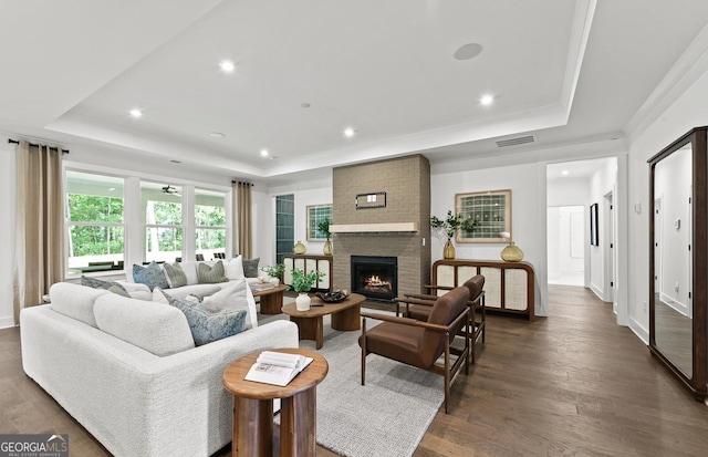 living room with recessed lighting, dark wood finished floors, visible vents, and a raised ceiling