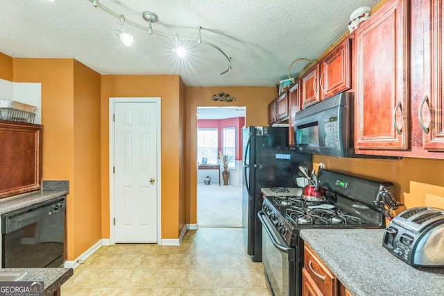 kitchen with a textured ceiling, baseboards, and black appliances