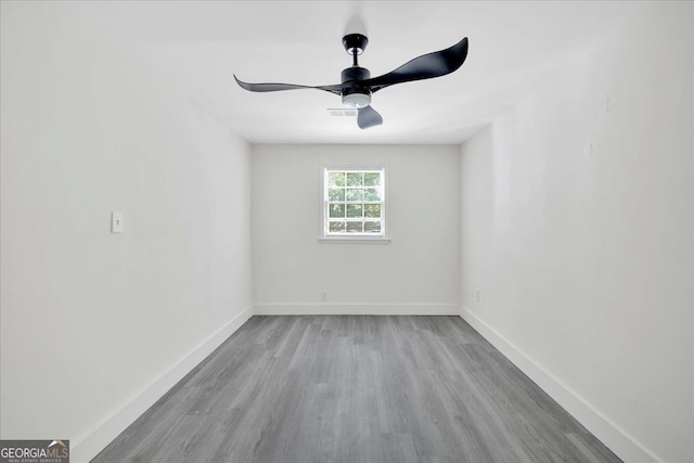 unfurnished room with wood finished floors, ceiling fan, visible vents, and baseboards