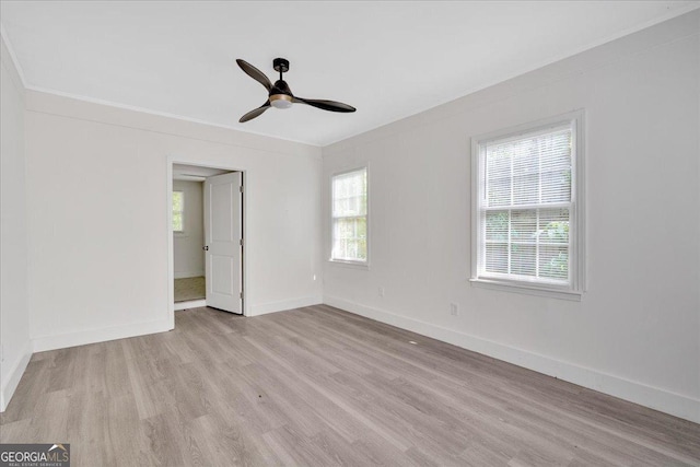 spare room with a wealth of natural light, ceiling fan, light wood-style flooring, and baseboards