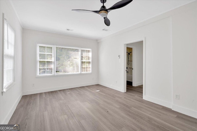unfurnished room featuring wood finished floors, ceiling fan, visible vents, and baseboards