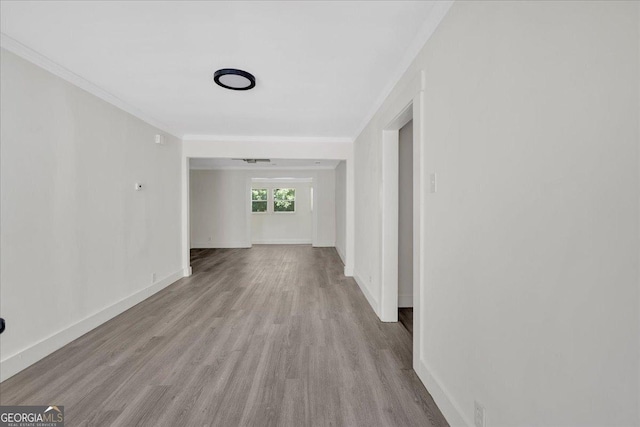 hall featuring crown molding, wood finished floors, and baseboards