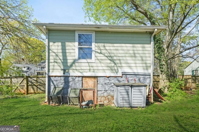rear view of property featuring a yard and fence