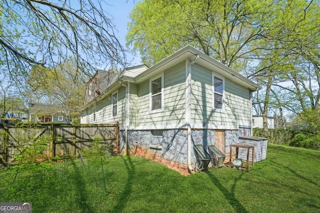 view of home's exterior with a yard and fence