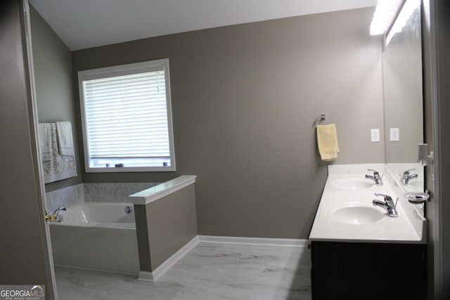 bathroom with a garden tub, marble finish floor, a sink, and double vanity