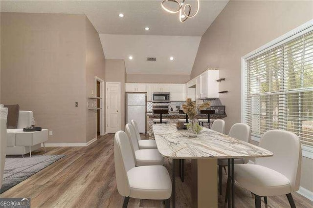 328 Allatoona Shores Dr, Canton, GA 30114 - dining area featuring visible vents, baseboards, high vaulted ceiling, and wood finished floors