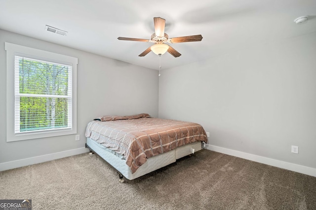 carpeted bedroom with baseboards, a ceiling fan, and visible vents