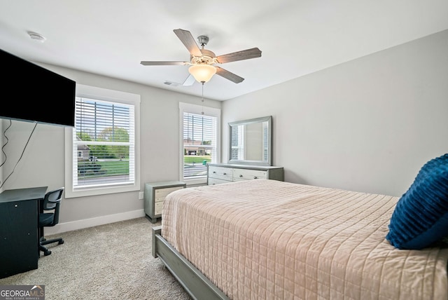 bedroom with visible vents, baseboards, a ceiling fan, and light carpet