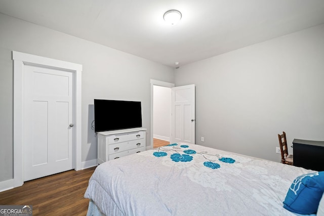 bedroom with wood finished floors and baseboards