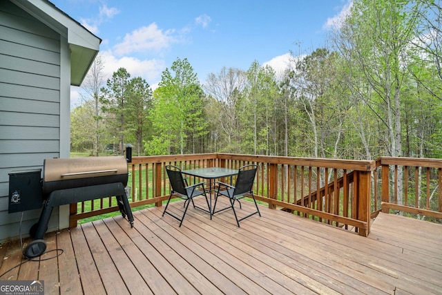 wooden deck with outdoor dining space and area for grilling