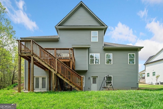 back of property with stairs, a yard, a wooden deck, and a shingled roof