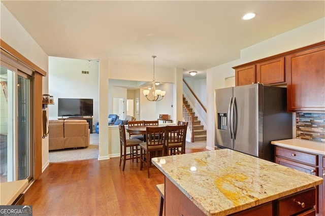 209 Crestmont Way, Canton, GA 30114 - kitchen with stainless steel refrigerator with ice dispenser, a chandelier, wood finished floors, open floor plan, and tasteful backsplash
