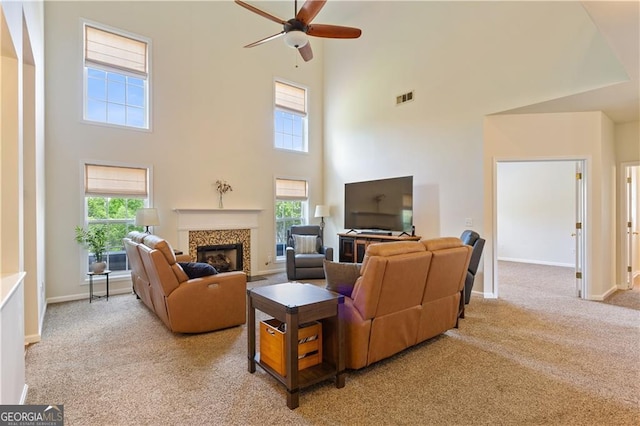 209 Crestmont Way, Canton, GA 30114 - living room with a towering ceiling, a ceiling fan, light carpet, a glass covered fireplace, and baseboards