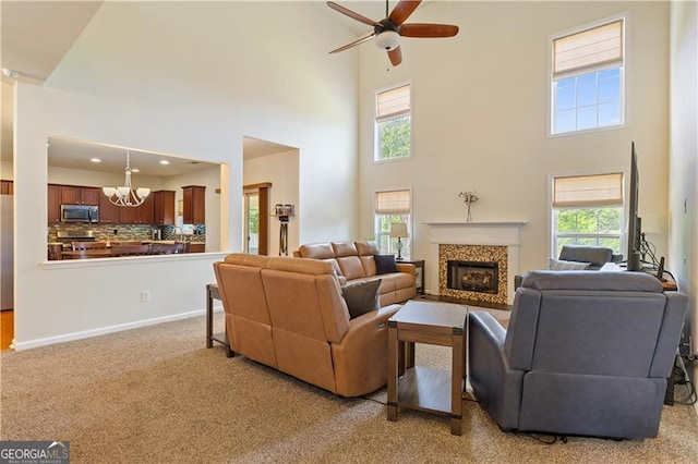 209 Crestmont Way, Canton, GA 30114 - living area with a chandelier, a high ceiling, a high end fireplace, a ceiling fan, and carpet floors