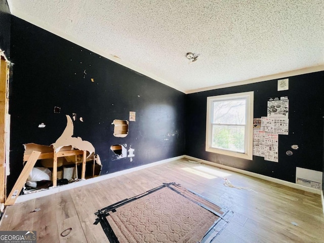 1546 Bob Mann Rd, Maysville, GA 30558 - unfurnished bedroom with a textured ceiling, wood finished floors, and baseboards