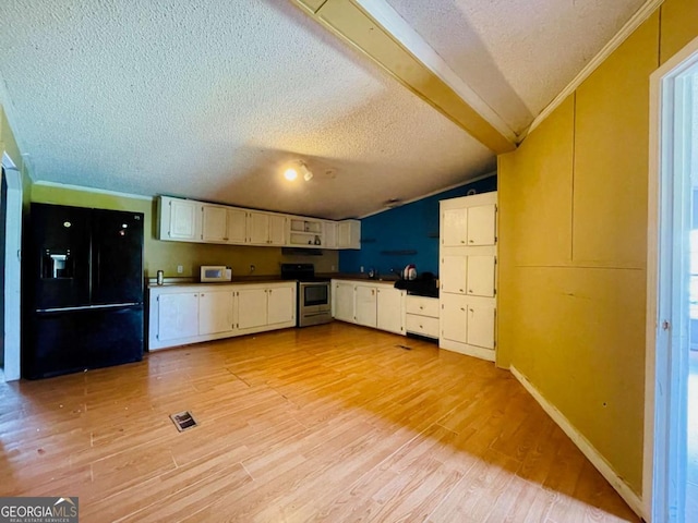 1546 Bob Mann Rd, Maysville, GA 30558 - kitchen with black fridge, a textured ceiling, white microwave, stainless steel range with electric cooktop, and light wood-style flooring