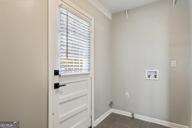clothes washing area featuring baseboards, dark tile patterned floors, laundry area, hookup for an electric dryer, and hookup for a washing machine