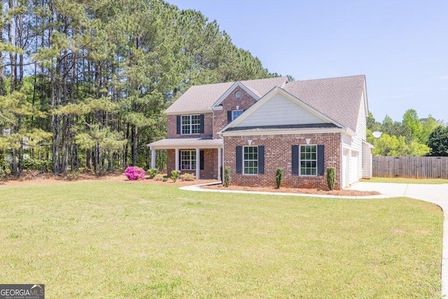 view of front facade featuring a front yard, fence, and brick siding