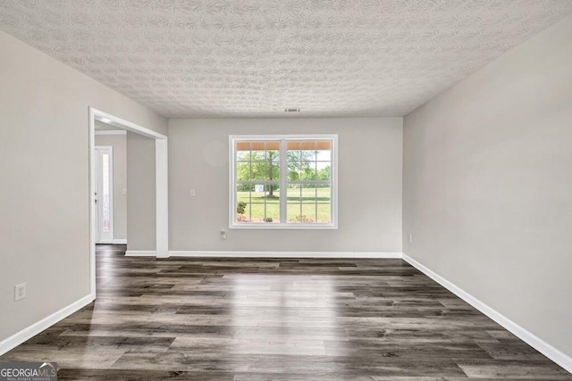 empty room with baseboards and wood finished floors
