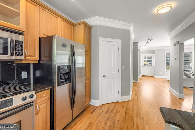 kitchen with baseboards, ornamental molding, light wood-type flooring, stainless steel appliances, and backsplash