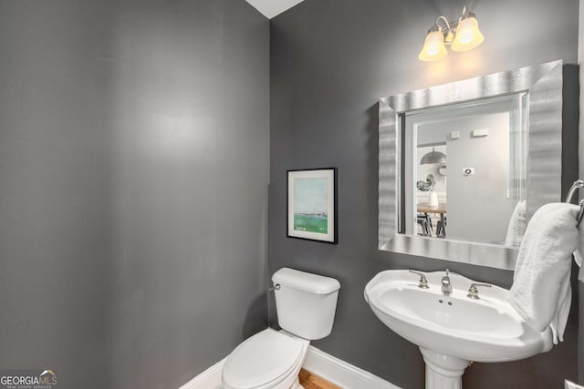 bathroom with baseboards, a sink, and toilet