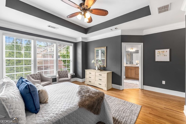 bedroom with visible vents, a tray ceiling, and baseboards