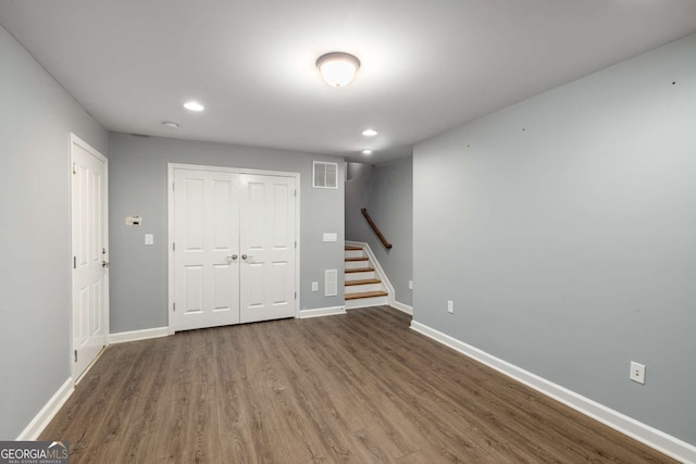 finished below grade area featuring visible vents, recessed lighting, wood finished floors, stairs, and baseboards