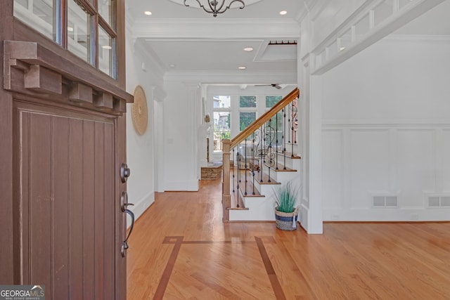 866 Coopers Ridge Path SW, Grayson, GA 30017 - entrance foyer featuring a decorative wall, crown molding, light wood-style floors, stairway, and ceiling fan