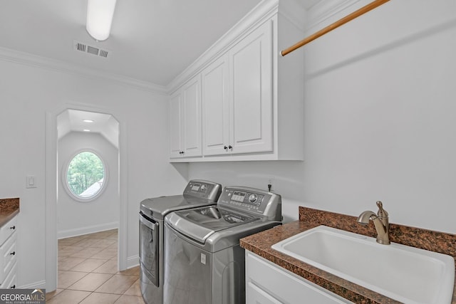 866 Coopers Ridge Path SW, Grayson, GA 30017 - laundry area featuring washing machine and clothes dryer, cabinet space, light tile patterned flooring, and crown molding