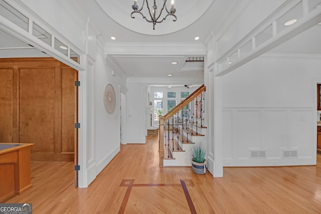 866 Coopers Ridge Path SW, Grayson, GA 30017 - entryway with a decorative wall, light wood finished floors, a chandelier, crown molding, and stairs