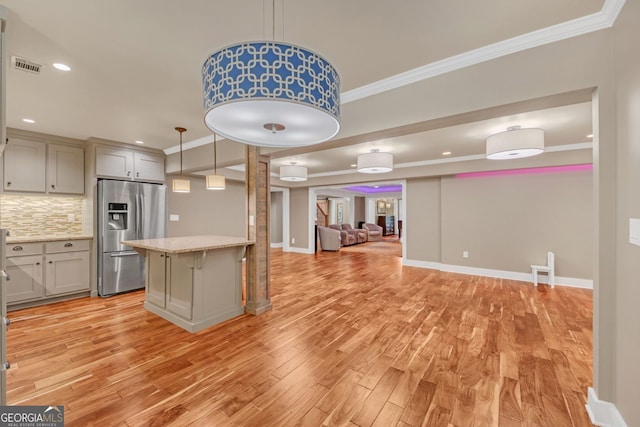 866 Coopers Ridge Path SW, Grayson, GA 30017 - kitchen featuring stainless steel fridge, light wood-style floors, ornamental molding, a kitchen breakfast bar, and tasteful backsplash