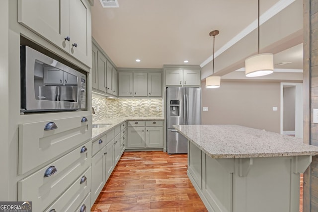 866 Coopers Ridge Path SW, Grayson, GA 30017 - kitchen with stainless steel appliances, a kitchen island, light wood-type flooring, tasteful backsplash, and light stone countertops
