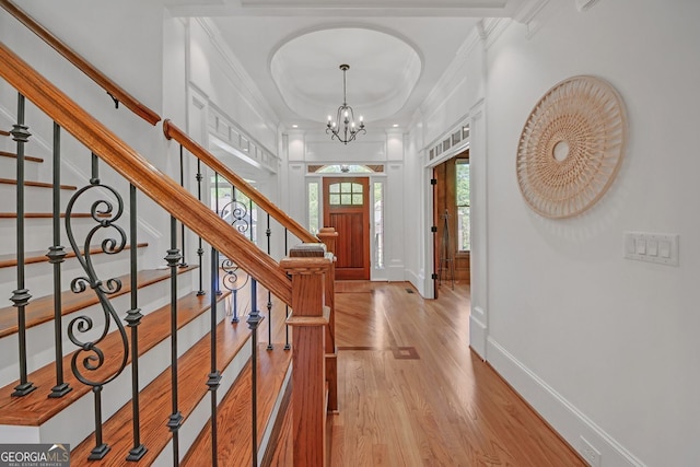 866 Coopers Ridge Path SW, Grayson, GA 30017 - entryway featuring ornamental molding, light wood finished floors, a chandelier, stairway, and a raised ceiling