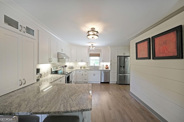 16080 Freemanville Rd, Alpharetta, GA 30004 - kitchen with appliances with stainless steel finishes, under cabinet range hood, a sink, white cabinetry, and light stone counters