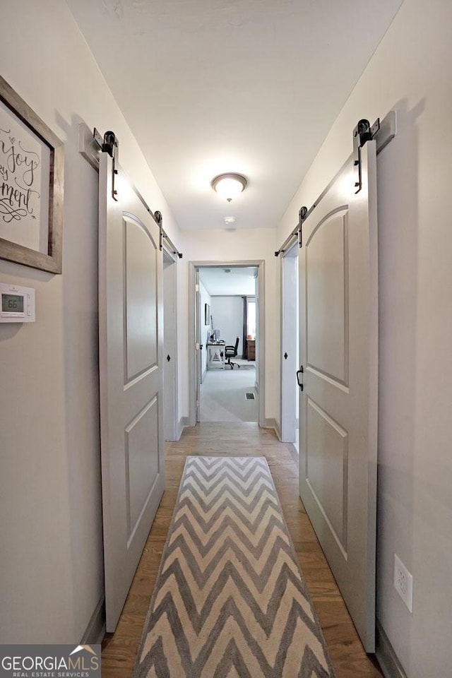16080 Freemanville Rd, Alpharetta, GA 30004 - hallway with a barn door and light wood finished floors
