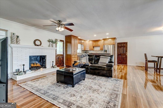 241 Burke Cir, Mcdonough, GA 30253 - living area with crown molding, light wood finished floors, a fireplace, and a ceiling fan