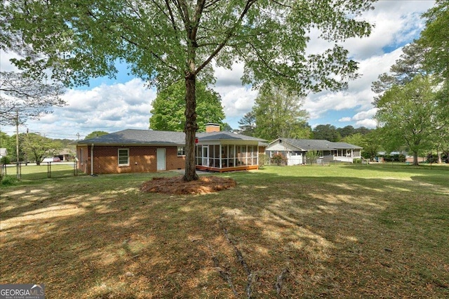 241 Burke Cir, Mcdonough, GA 30253 - back of house featuring fence, a yard, brick siding, and a sunroom