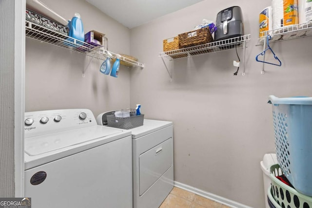 840 Whitby Dr, Douglasville, GA 30134 - laundry room with washer and clothes dryer, light tile patterned flooring, laundry area, and baseboards