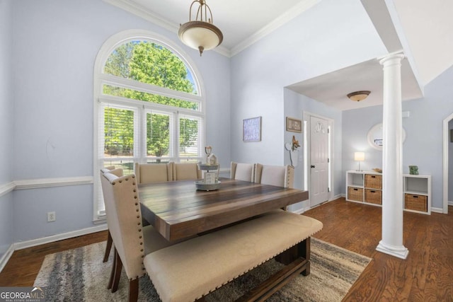 840 Whitby Dr, Douglasville, GA 30134 - dining room featuring crown molding, ornate columns, a towering ceiling, wood finished floors, and baseboards