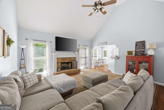 840 Whitby Dr, Douglasville, GA 30134 - living room featuring a stone fireplace, baseboards, a ceiling fan, high vaulted ceiling, and arched walkways