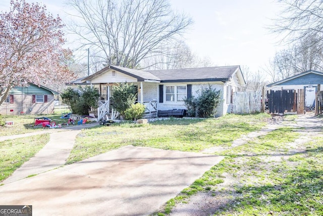 view of front of home featuring covered porch, a front yard, fence, and brick siding
