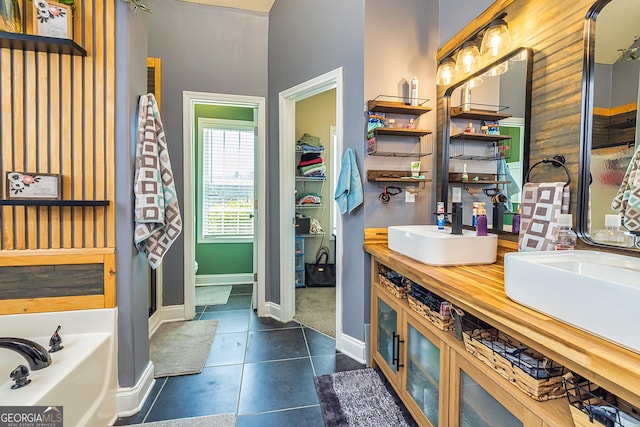 208 Jasmine Ln, Lagrange, GA 30241 - bathroom featuring a sink, a bath, double vanity, baseboards, and tile patterned flooring