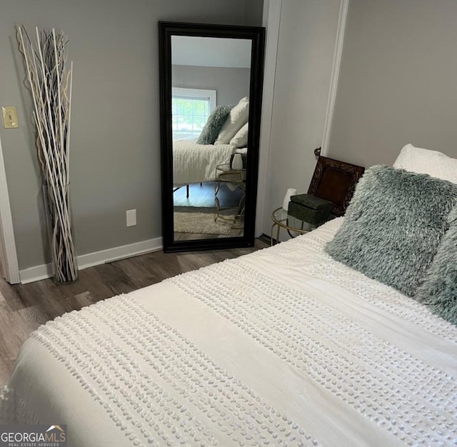 bedroom featuring baseboards and wood finished floors