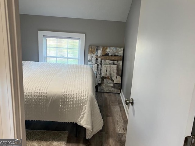 bedroom with baseboards and wood finished floors