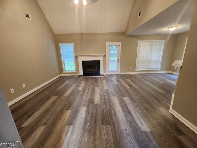 unfurnished living room with high vaulted ceiling, a high end fireplace, visible vents, and baseboards