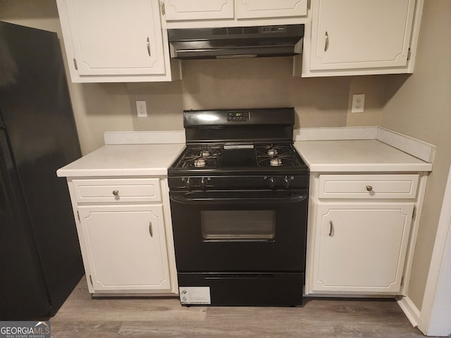 kitchen with light countertops, white cabinetry, under cabinet range hood, black appliances, and wood finished floors